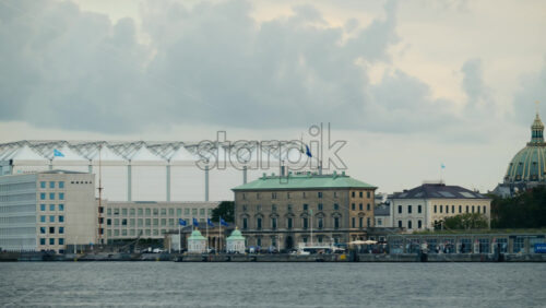 Video - Copenhagen, Denmark - August 2, 2025: Copenhagen harbor showing waterfront buildings and a yellow ferry passing on the water