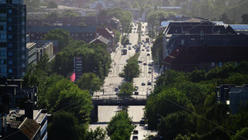 Video - Copenhagen, Denmark - August 4, 2025: Urban cityscape showing a busy street, buildings, and green trees on a hazy morning in Copenhagen