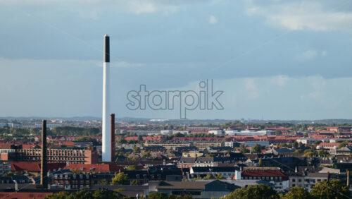 Video - Copenhagen cityscape showcasing buildings, red rooftops, and diverse urban architecture under a cloudy sky. Denmark