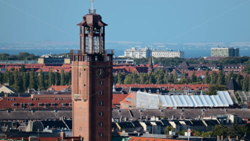 Video - Clock tower dominating the urban landscape with red rooftops. Copenhagen, Denmark