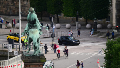 Video - Copenhagen, Denmark - August 3, 2025: Absalon statue with people, cars, and cyclists moving in hojbro plads