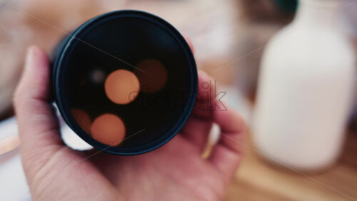 Video - Close up of camera lens with warm bokeh light reflections inside the glass