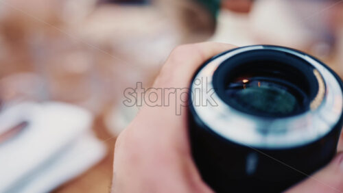 Video - Close up of a camera lens held in hand with soft background bokeh