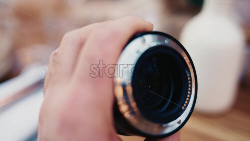 Video - Close up of a camera lens held in hand with soft background bokeh