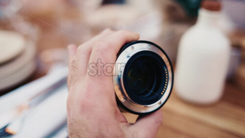Video - Close up of a camera lens held in hand with soft background bokeh
