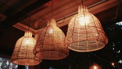 Video - Decorative wicker lamps hanging indoors with warm light with a cozy and stylish interior atmosphere