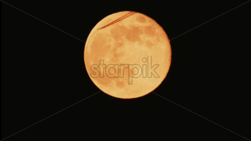 Video - Large full moon rising against a dark night sky with clear details and dramatic atmosphere