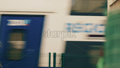 Video - Abstract shot of a high speed train passing behind a metal fence, creating motion blur and geometric line