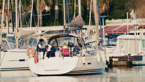 Video - Antibes, France - December 17, 2025: Sailboat slowly moving through a marina surrounded by moored yachts