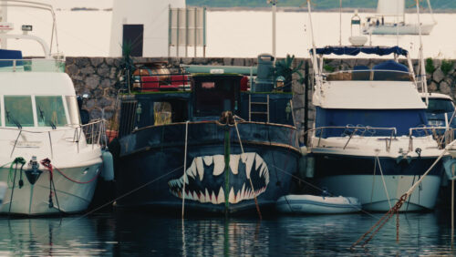Video - Antibes, France - December 17, 2025: Front view of a moored boat featuring a painted shark mouth design on the hull