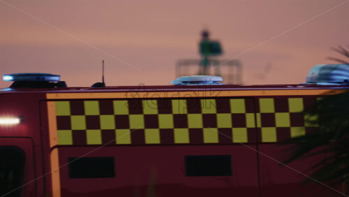 Video - Side view of a red ambulance moving through Antibes during dusk