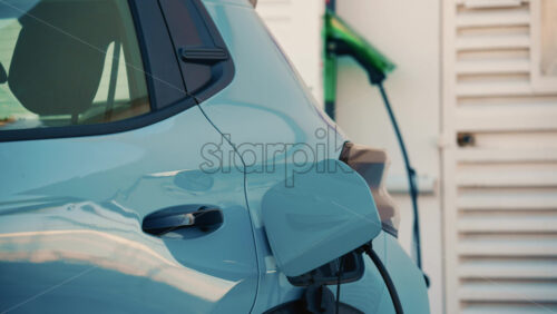 Video - Close up of a white electric car connected to a charging station