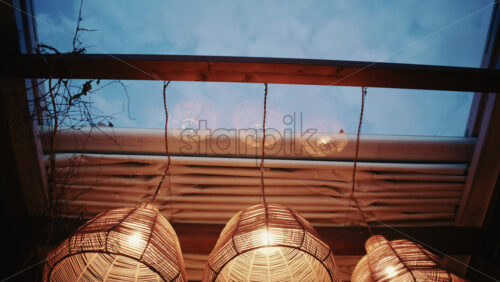 Video - Decorative wicker lamps hanging indoors with warm light with a cozy and stylish interior atmosphere