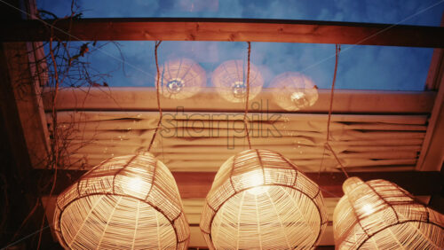 Video - Decorative wicker lamps hanging indoors with warm light with a cozy and stylish interior atmosphere