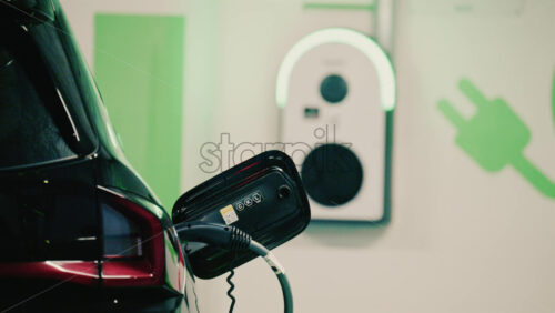 Video - Close up view of a black electric car plugged into a charging station