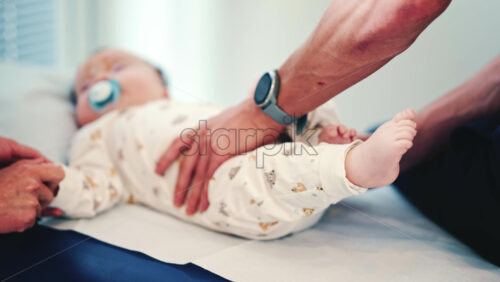 Video - Calm baby wearing a pacifier lying on a medical or therapy table during a pediatric session