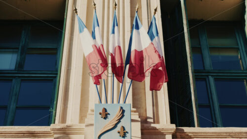 Video - French national flags waving on the facade of a historic building in southern France