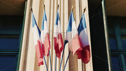 Video - French national flags waving on the facade of a historic building in southern France