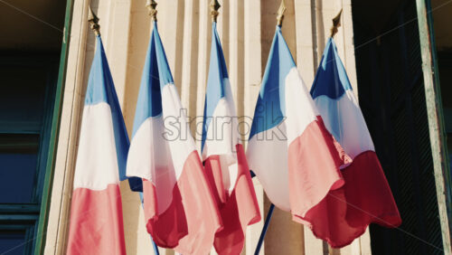 Video - French national flags waving on the facade of a historic building in southern France