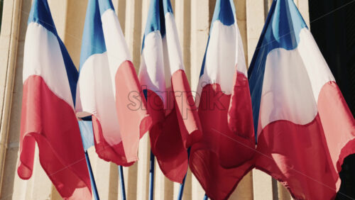 Video - French national flags waving on the facade of a historic building in southern France