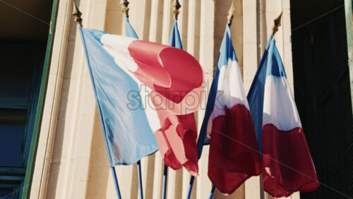 Video - French national flags waving on the facade of a historic building in southern France