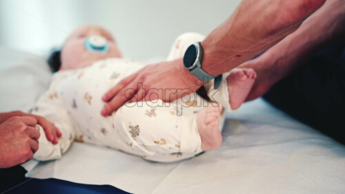 Video - Calm baby wearing a pacifier lying on a medical or therapy table during a pediatric session