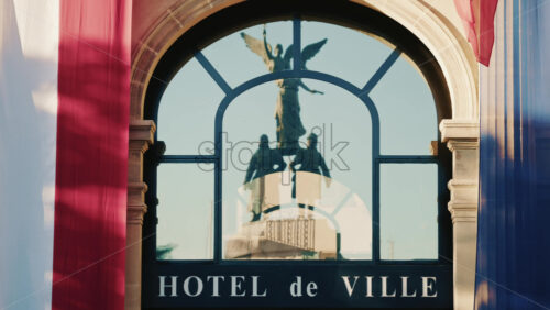 Video - French city hall entrance with tricolor flags and reflection of a monument in the glass