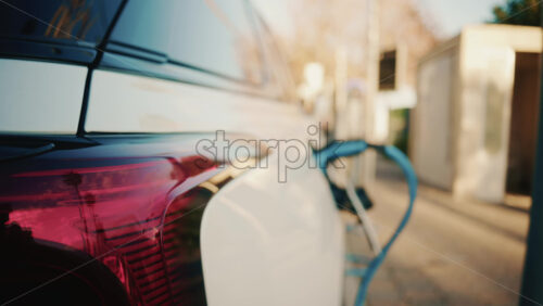 Video - Close up of a white electric car connected to a charging station