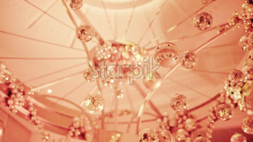 Video - Close up view of elegant golden Christmas ornaments suspended indoors with warm festive lighting