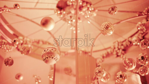 Video - Close up view of elegant golden Christmas ornaments suspended indoors with warm festive lighting