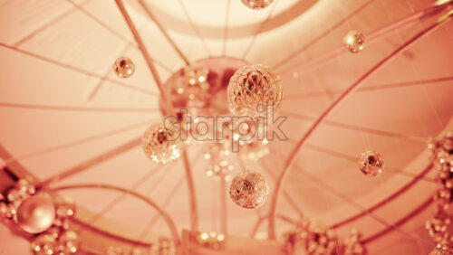 Video - Close up view of elegant golden Christmas ornaments suspended indoors with warm festive lighting