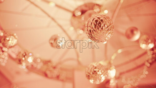 Video - Close up view of elegant golden Christmas ornaments suspended indoors with warm festive lighting