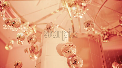 Video - Close up view of elegant golden Christmas ornaments suspended indoors with warm festive lighting
