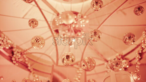 Video - Close up view of elegant golden Christmas ornaments suspended indoors with warm festive lighting