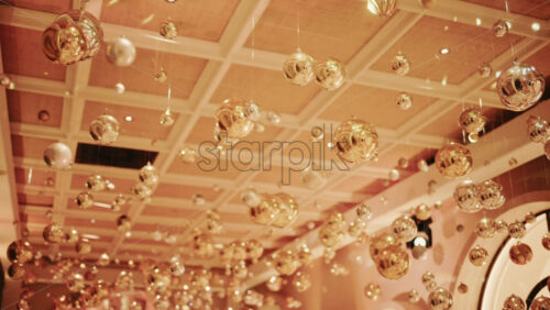 Video - Decorative golden Christmas ornaments suspended in an elegant indoor display