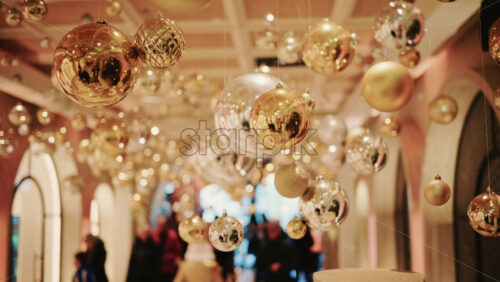 Video - Decorative golden Christmas ornaments suspended in an elegant indoor display