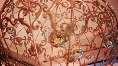 Video - Close up of decorative Christmas ornaments hanging from an ornate metal structure