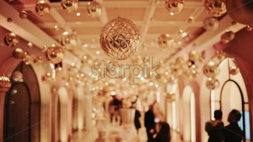 Video - Decorative Christmas ornament suspended under an illuminated arch with warm golden lighting