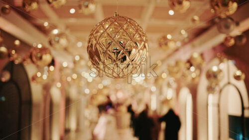 Video - Decorative Christmas ornament suspended under an illuminated arch with warm golden lighting