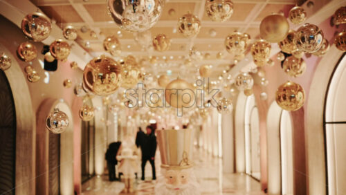 Video - Decorative Christmas ornament suspended under an illuminated arch with warm golden lighting