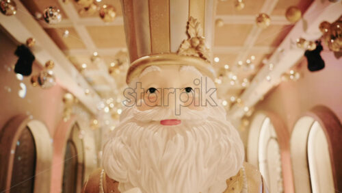 Video - Close up of a Santa Claus figure inside a festive Christmas installation with warm lights and ornaments