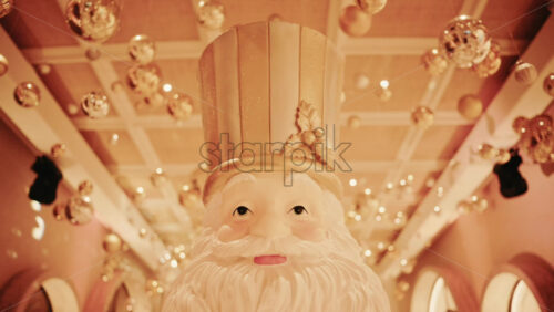 Video - Close up of a Santa Claus figure inside a festive Christmas installation with warm lights and ornaments