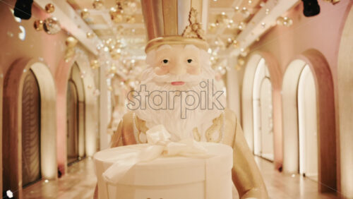 Video - Close up of a Santa Claus figure inside a festive Christmas installation with warm lights and ornaments