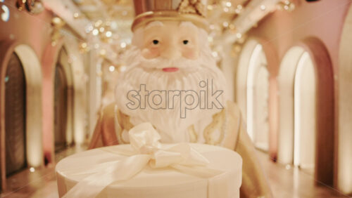 Video - Close up of a Santa Claus figure inside a festive Christmas installation with warm lights and ornaments