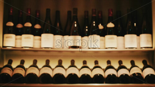 Video - Rows of wine bottles neatly arranged on softly lit shelves in a wine cellar or restaurant interior
