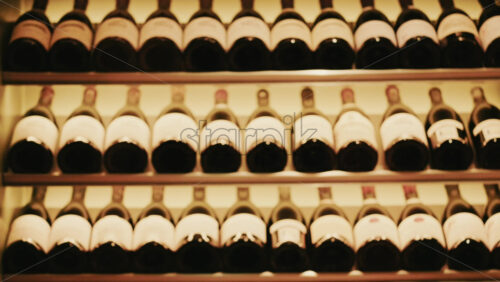 Video - Rows of wine bottles neatly arranged on softly lit shelves in a wine cellar or restaurant interior