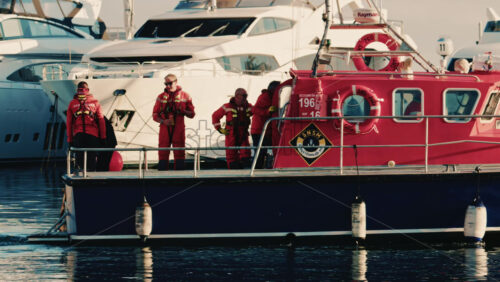 Video - Antibes, France - December 22, 2025: Red French sea rescue boat docked in a marina with crew members on board