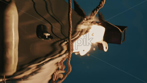 Video - Close up of a boat light reflecting on gently rippling water in a marina on the French Riviera