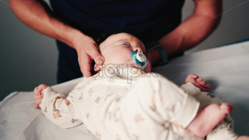 Video - Professional caregiver gently supports an infant's head and neck during a pediatric or therapeutic session