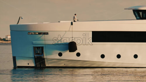 Video - Cannes, France - December 22, 2025: Detailed close up of a luxury yacht hull with a hanging black fender and waterline visible